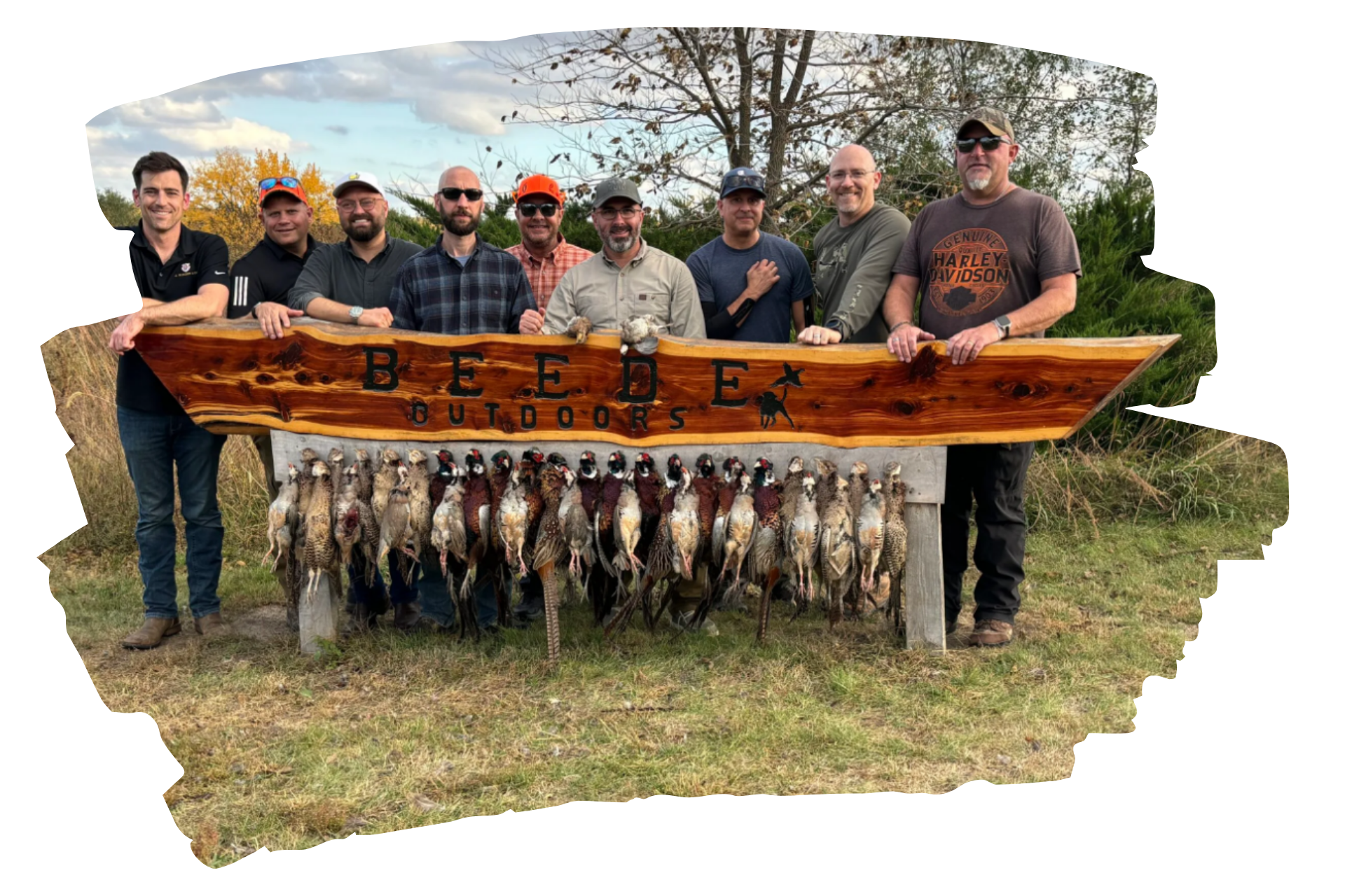 Group of men with harvested pheasants displayed on a table with