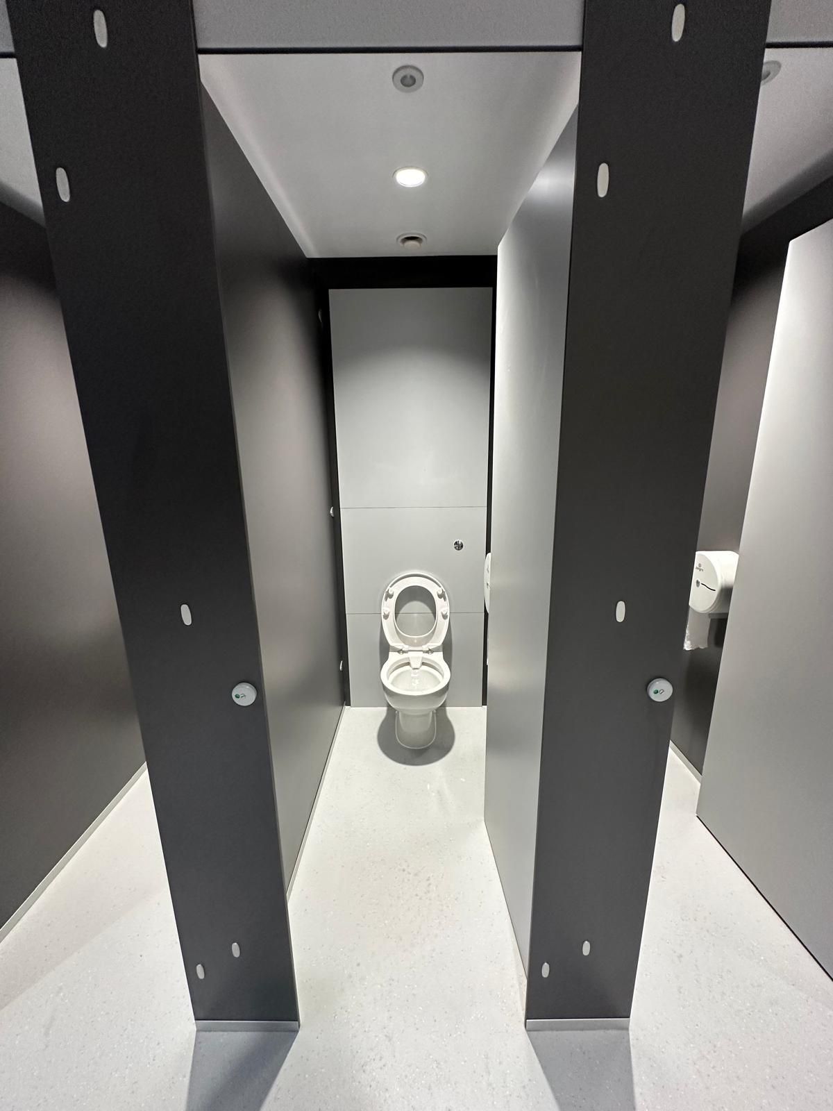 A public restroom with a toilet between two columns