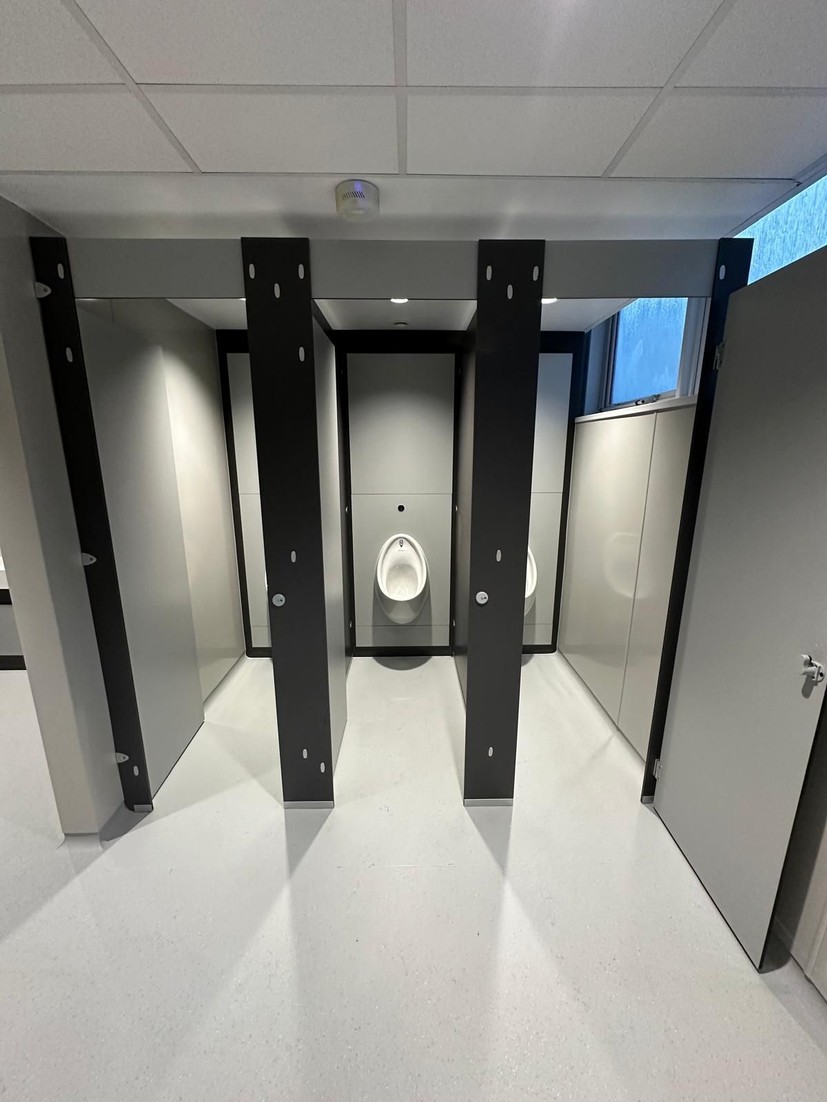 A bathroom with a urinal in the middle of it