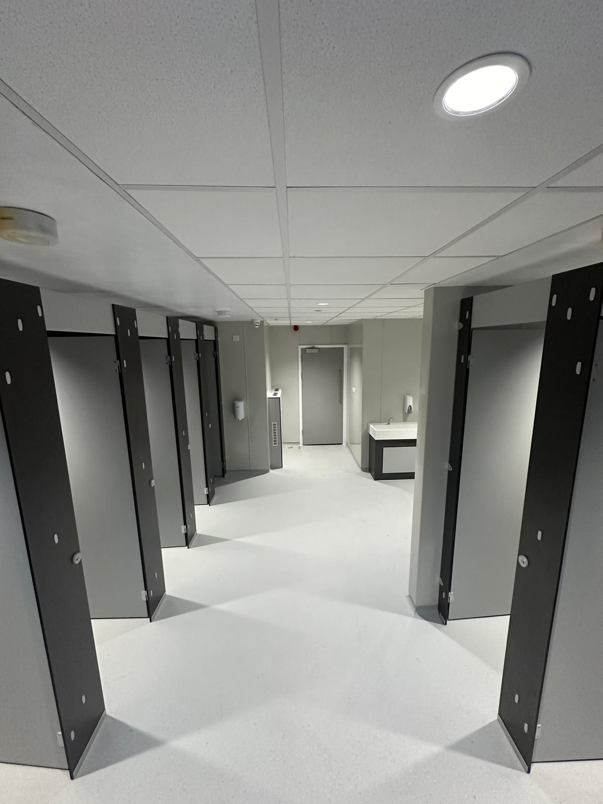 A hallway with a lot of doors and a light on the ceiling