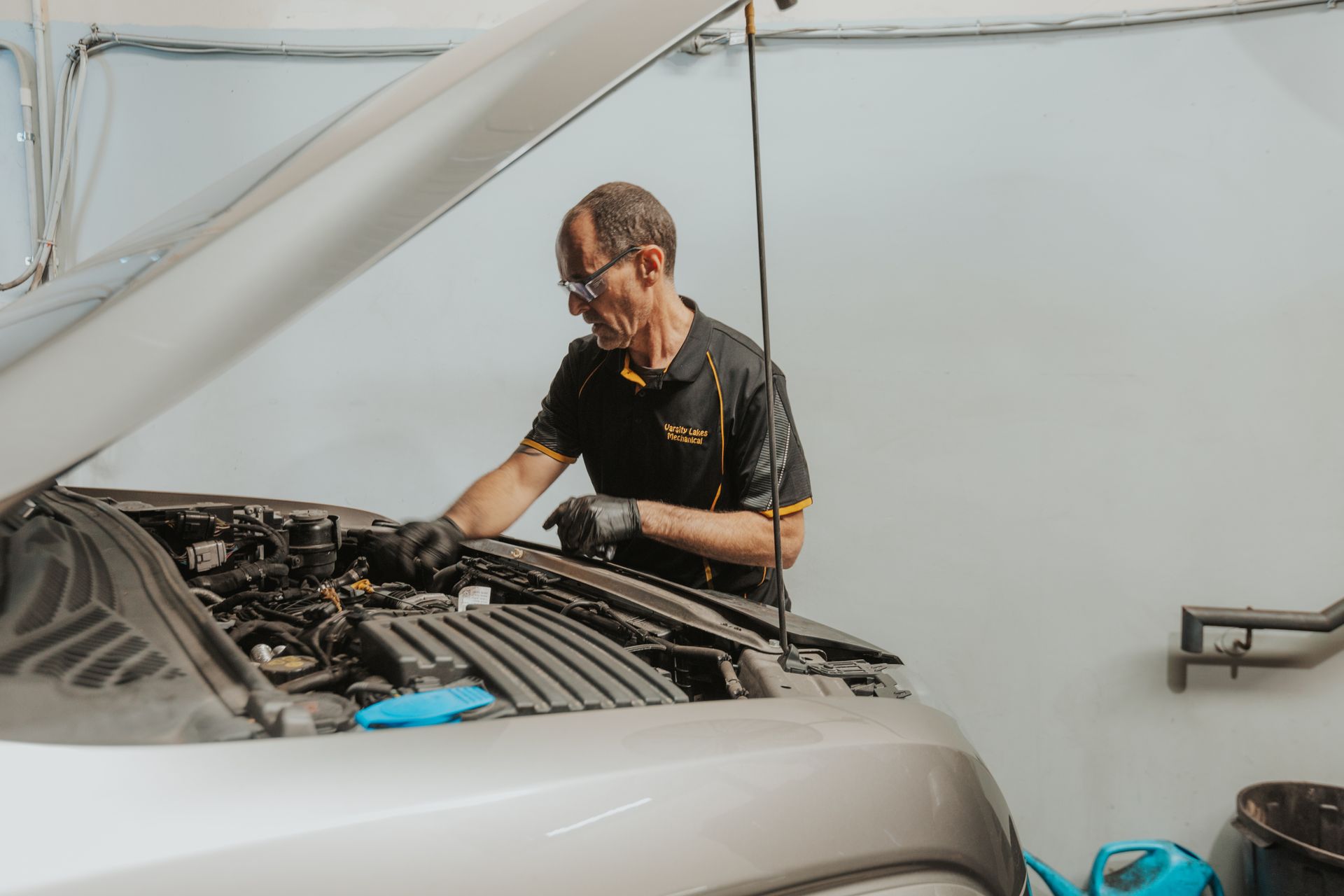 A Red Car With the Hood Up is on a Lift in a Garage — Varsity Lakes Mechanical Repairs In Varsity Lakes, QLD