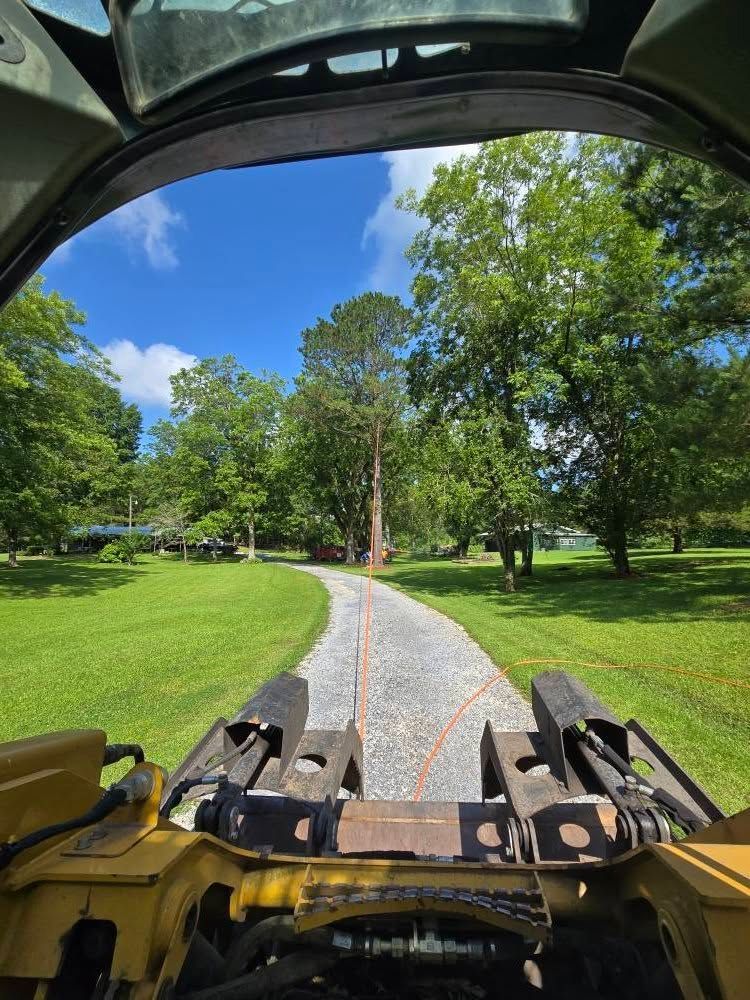 A tractor is driving down a dirt road in a park.