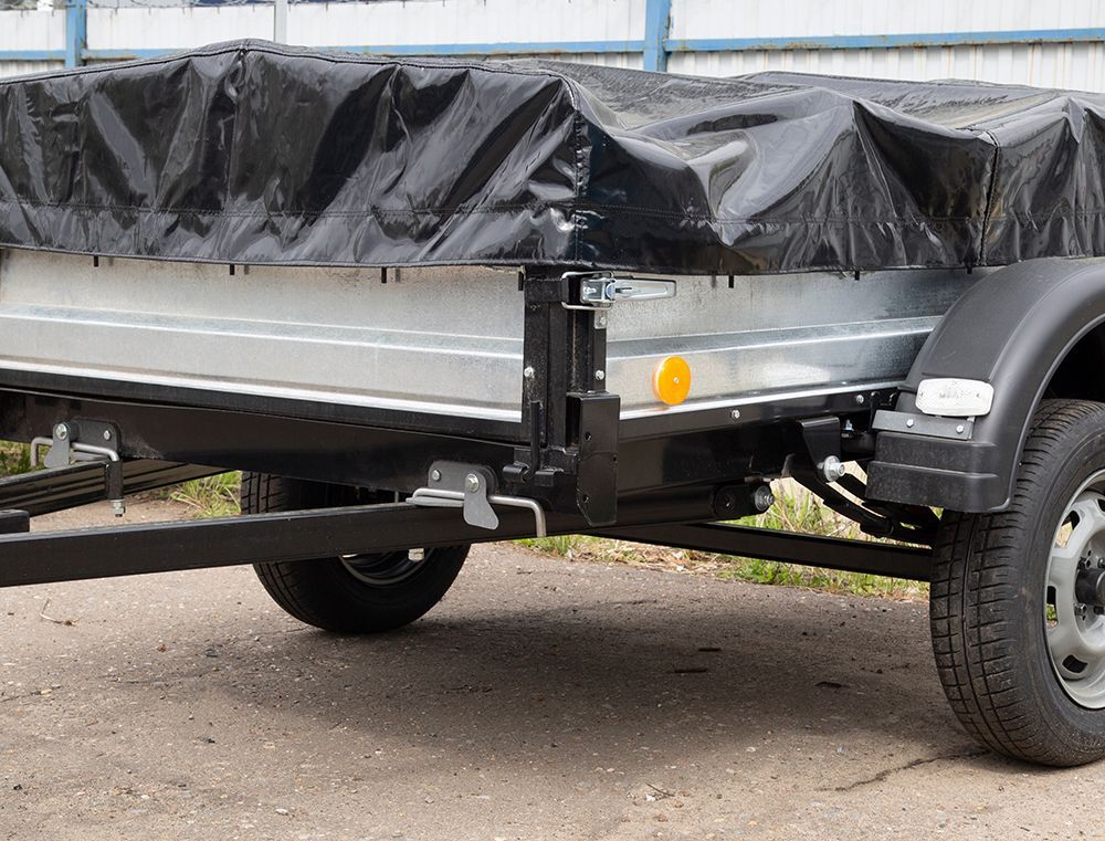 A small utility trailer with a black cover and black frame.