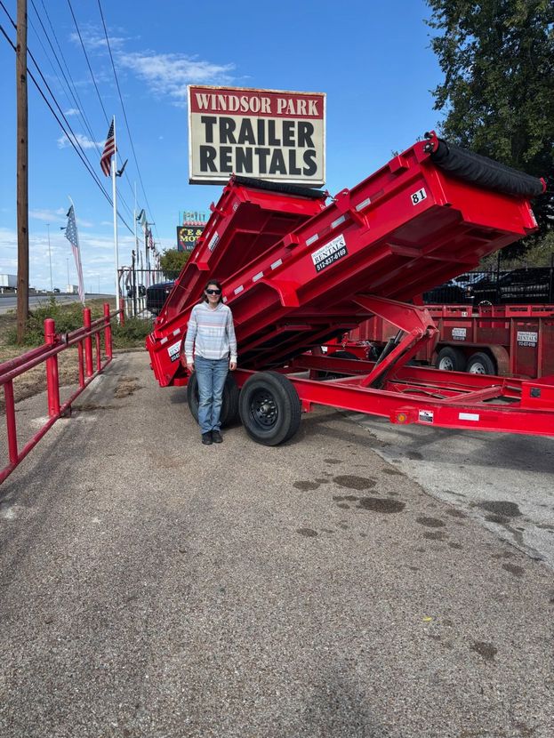 A small utility trailer with a black cover and black frame.