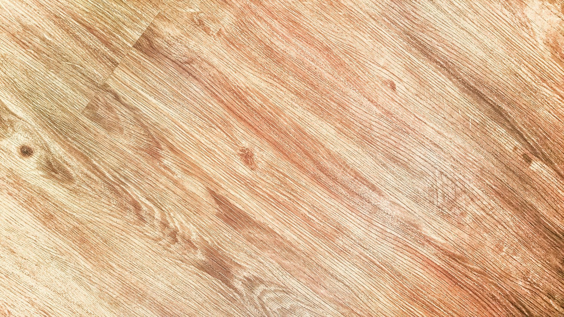 Light-brown wooden floor with diagonal planks, displaying wood grain texture and subtle color variations.