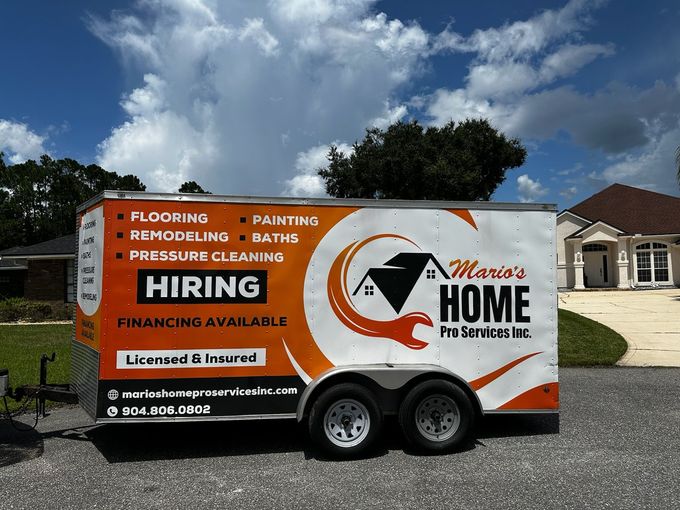 A trailer that says hiring on it is parked in front of a house.