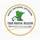 Golden logo for Todd Martin Realty on a golf course. The logo has a golf flag.