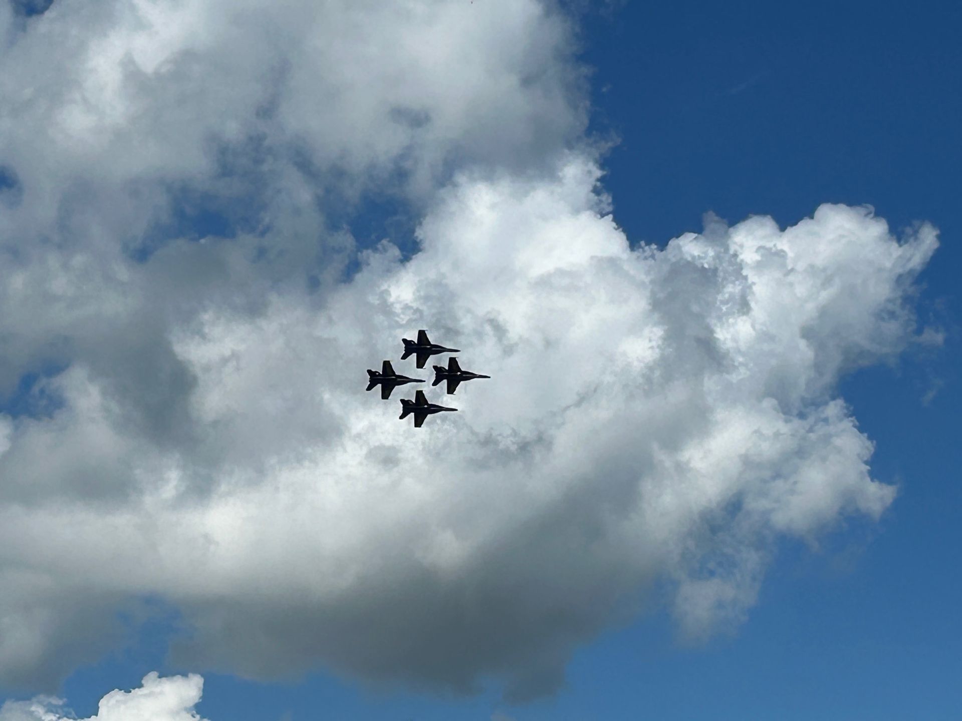 Four fighter jets are flying in formation in the sky