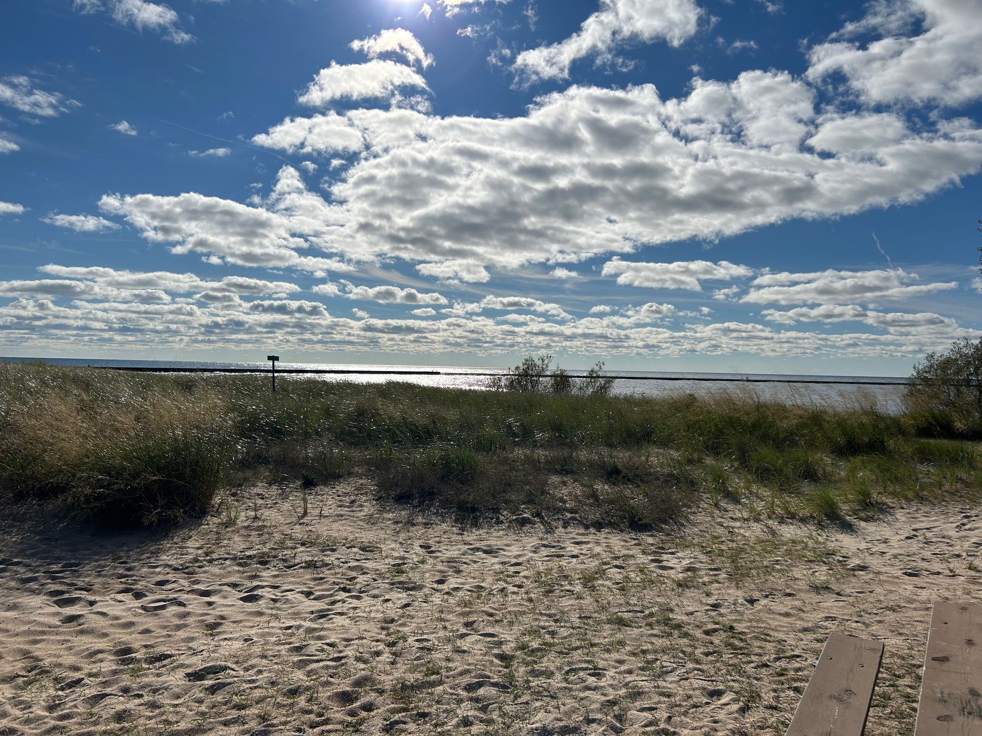 A view of the ocean from a sandy beach on a cloudy day