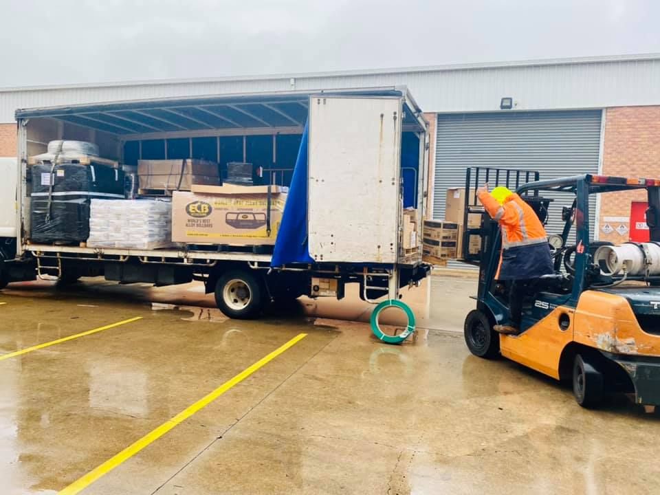 Man is Loading a Truck With a Forklift in a Parking Lot — Grants Express in Cowra, NSW