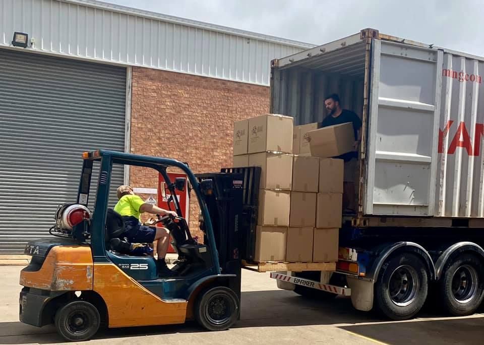 Man is Loading Boxes Into a Container With a Forklift — Grants Express in Bathurst, NSW