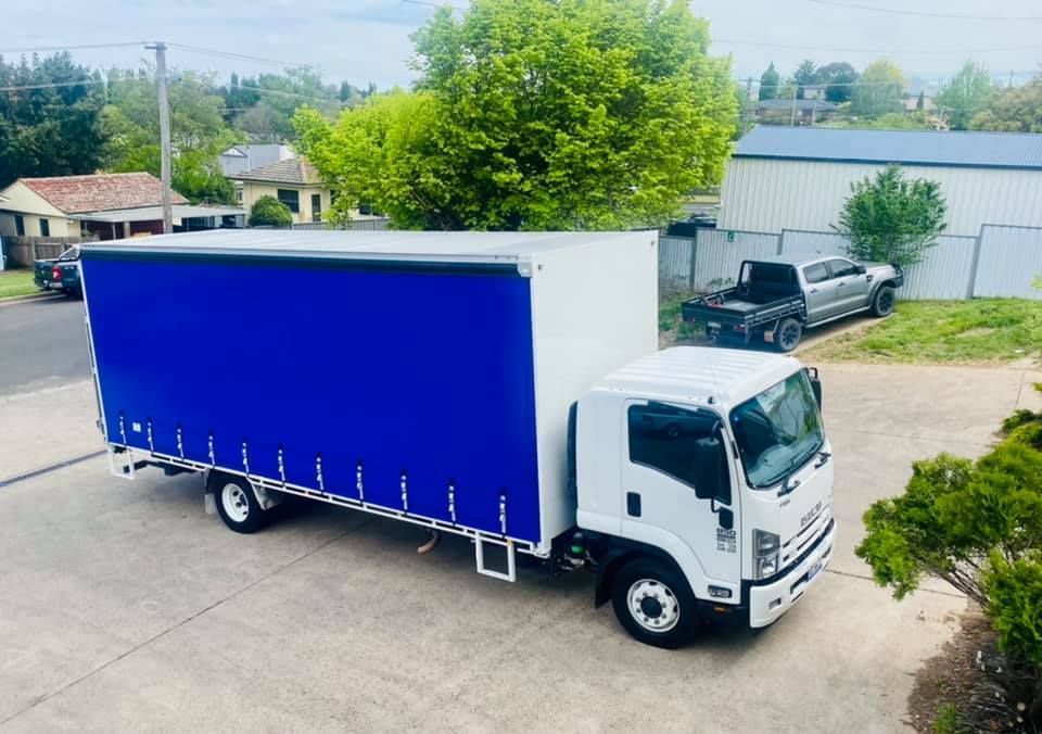 White Truck With a Blue Canopy is Parked on the Side of the Road — Grants Express in Lithgow, NSW