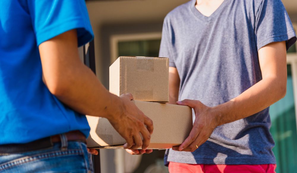 Delivery Man is Handing a Box to a Woman — Grants Express in Lithgow, NSW