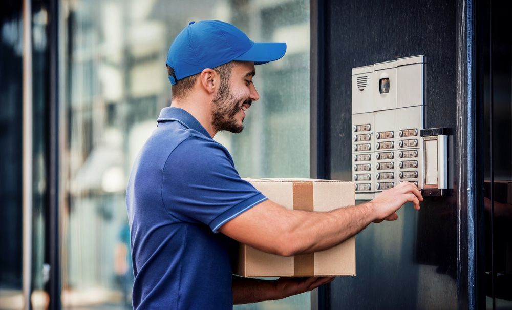Delivery Man is Holding a Box and Pressing a Button on a Door — Grants Express in Bathurst, NSW