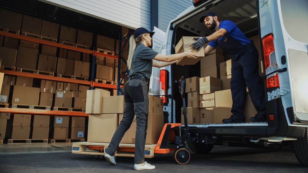 Man and a Woman Are Shaking Hands While Loading Boxes Into a Van — Grants Express in Smeaton Grange, NSW