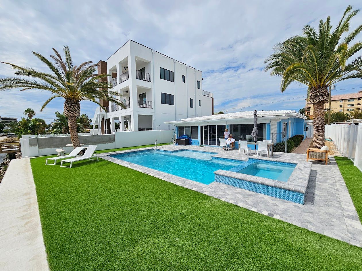 There is a large swimming pool in the backyard of a house.