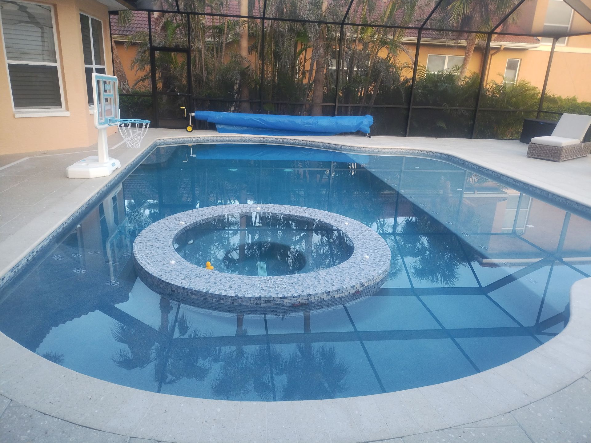 A large swimming pool with a hot tub in the middle