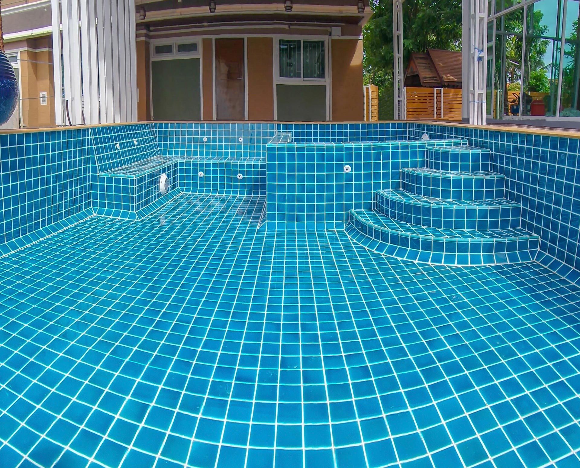 Swimming pool installation contractor showcasing a custom tiled in-ground pool under construction.