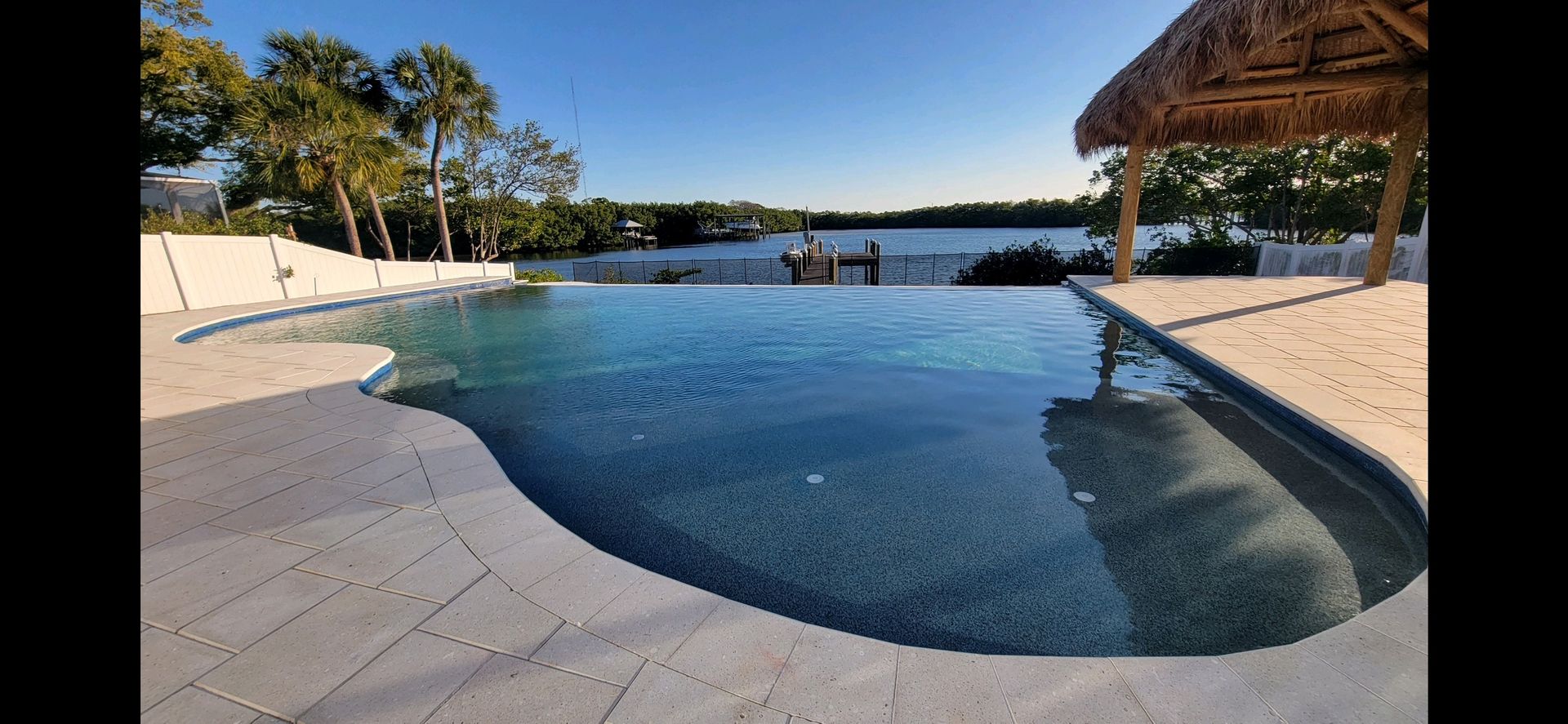 A large swimming pool with a view of a lake.