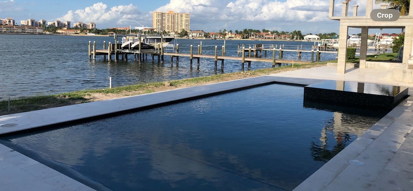 A large swimming pool surrounded by water and a dock.