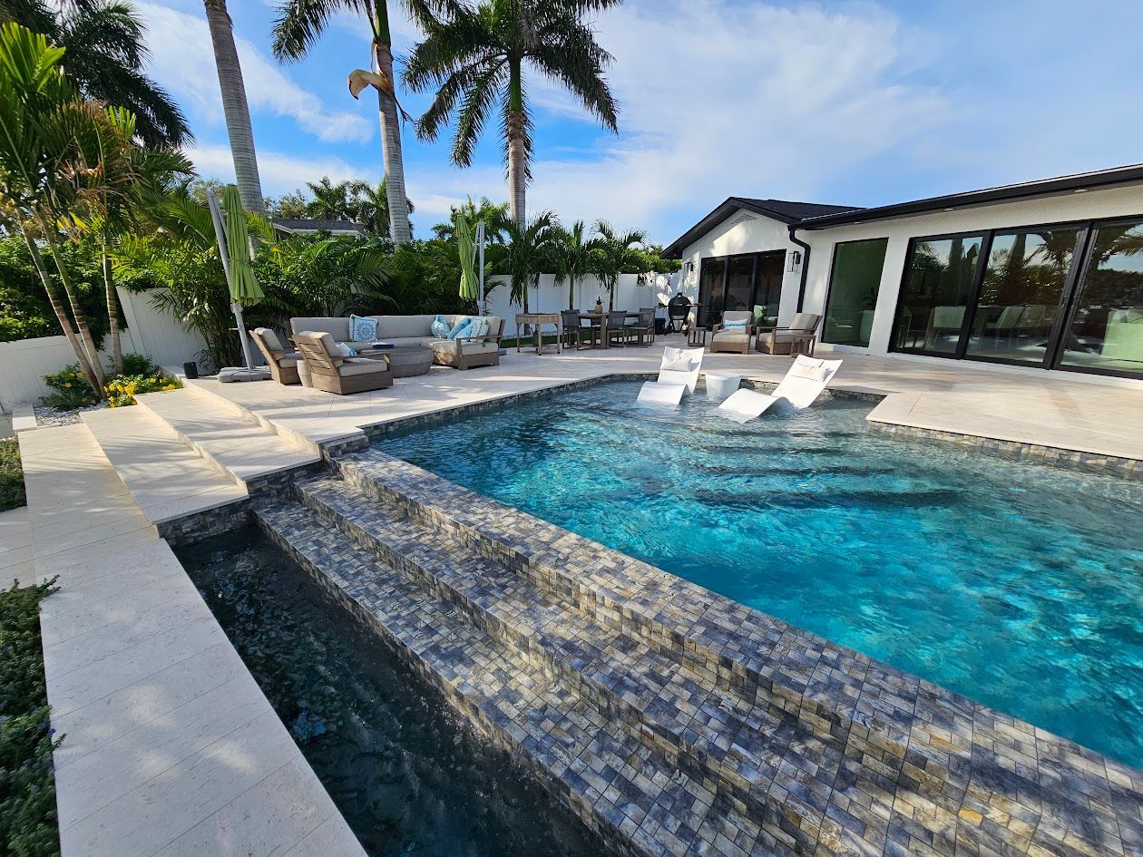 There is a large swimming pool in the backyard of a house.