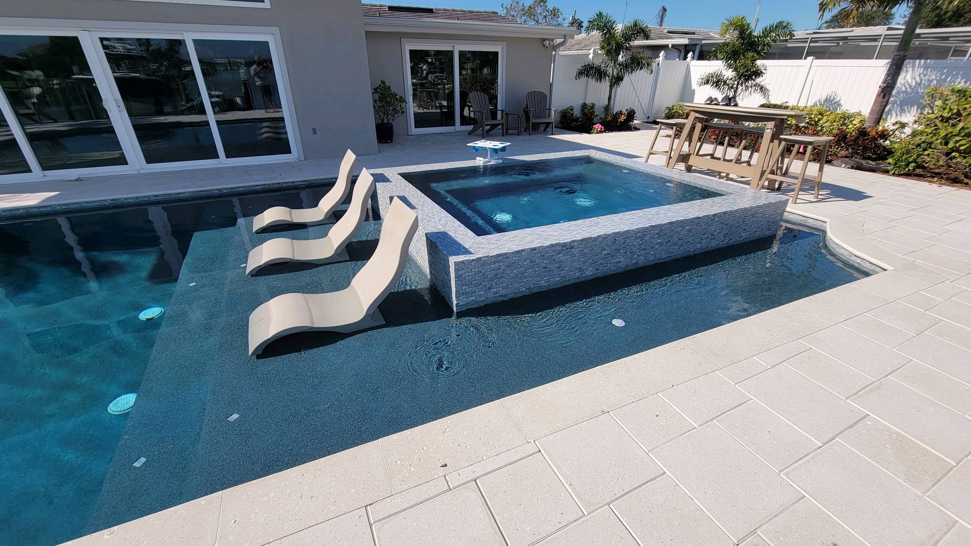 A large swimming pool with a hot tub in the middle of it.