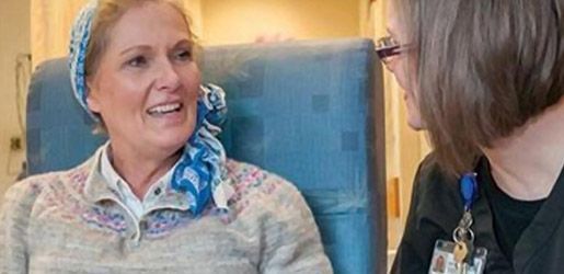 Woman in a headscarf talks to a healthcare worker in a care facility.