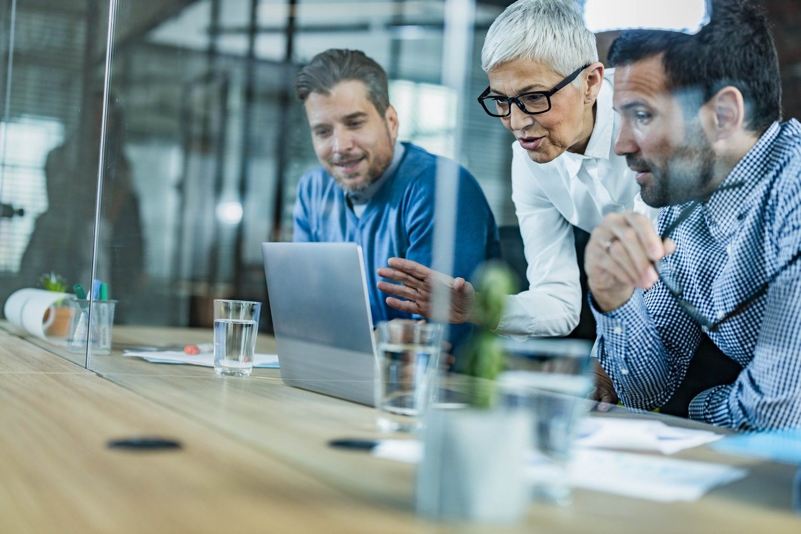 Un gruppo di persone è seduto a un tavolo e guarda un computer portatile.