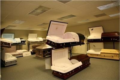 A room filled with lots of coffins including one that is open