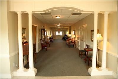 A hallway with columns and chairs in a building