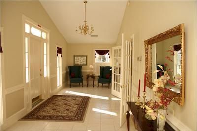 A hallway with a table and chairs and a mirror