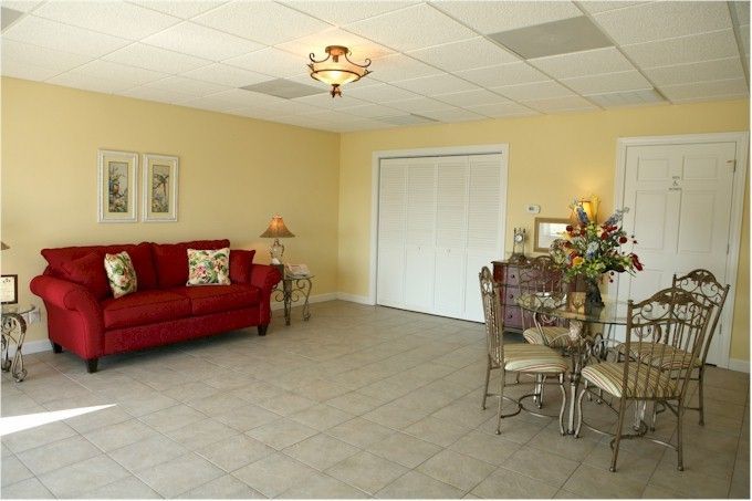 A living room with a red couch a table and chairs