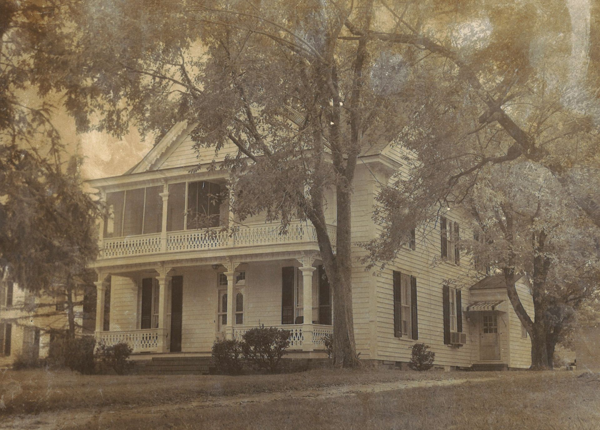 A black and white photo of a house with a porch