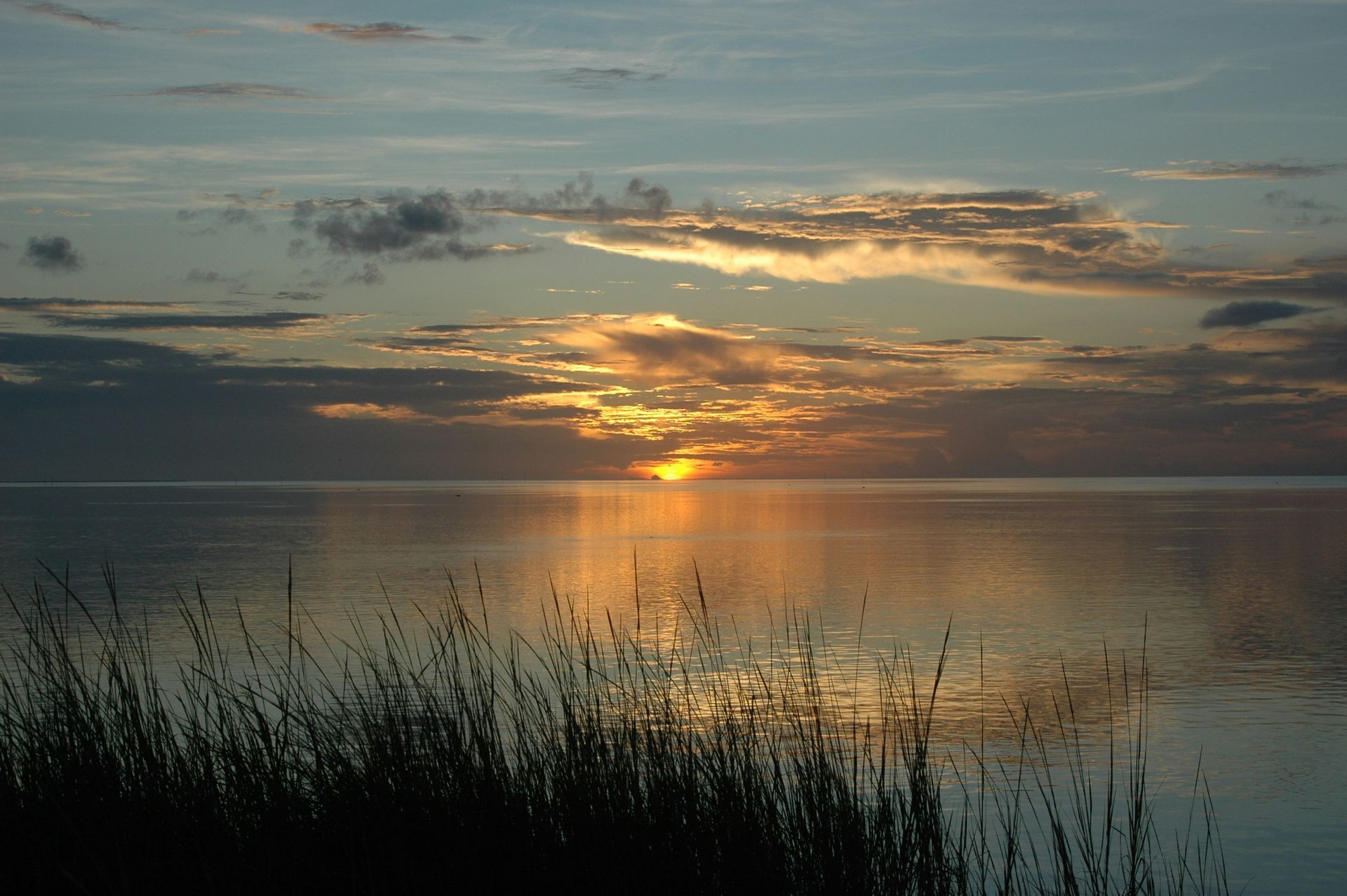 a sunset over a mountain range with a cloudy sky