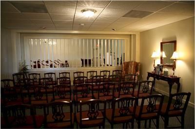 A room with rows of chairs and a window with blinds