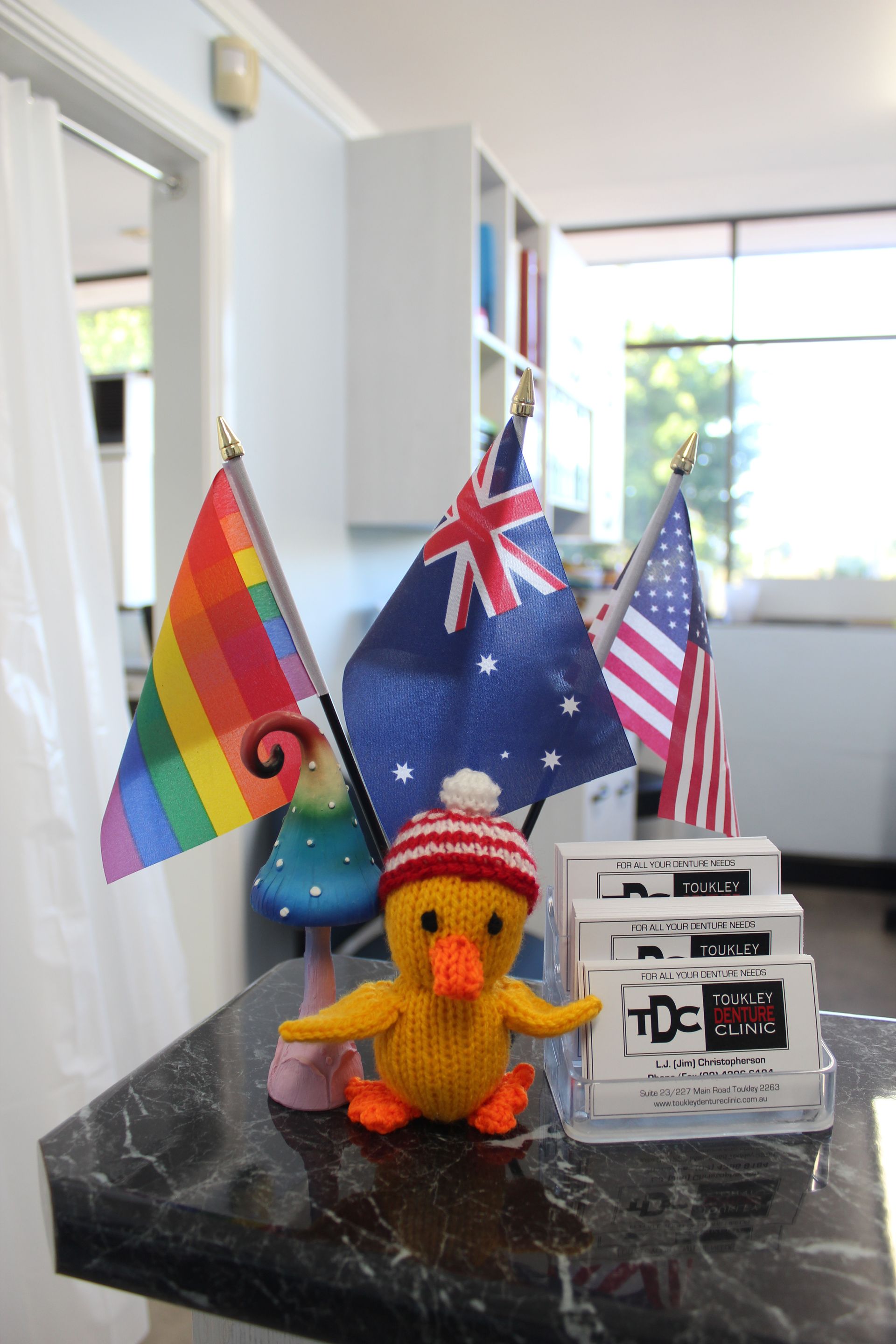 American flag, LGTBQ+ flag and the Australian flag on a reception desk — Dentures in Toukley, NSW