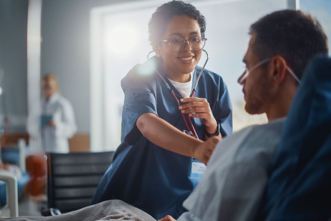 A doctor is talking to an elderly woman in a hospital bed.