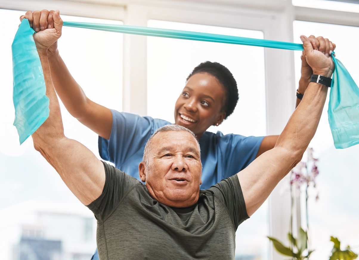 A nurse is helping an elderly man do exercises with a resistance band.