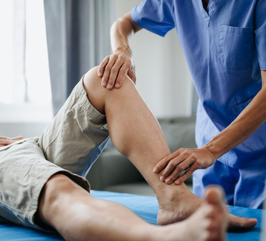 A man is undergoing physical therapy with a nurse.