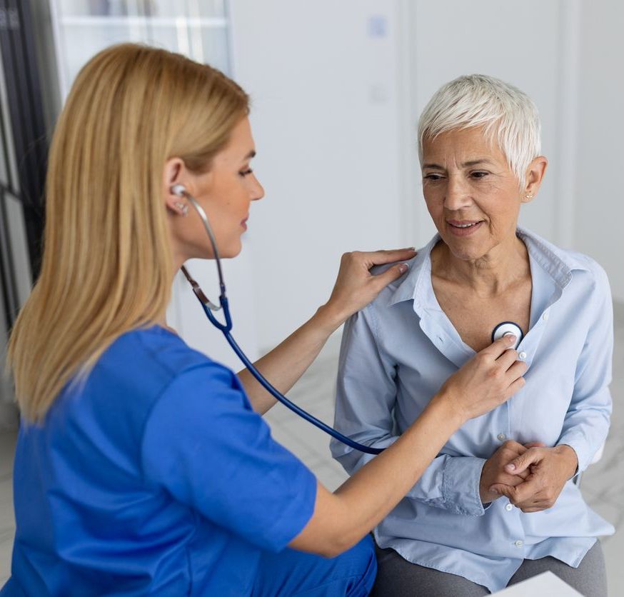 A nurse is examining an older man's throat