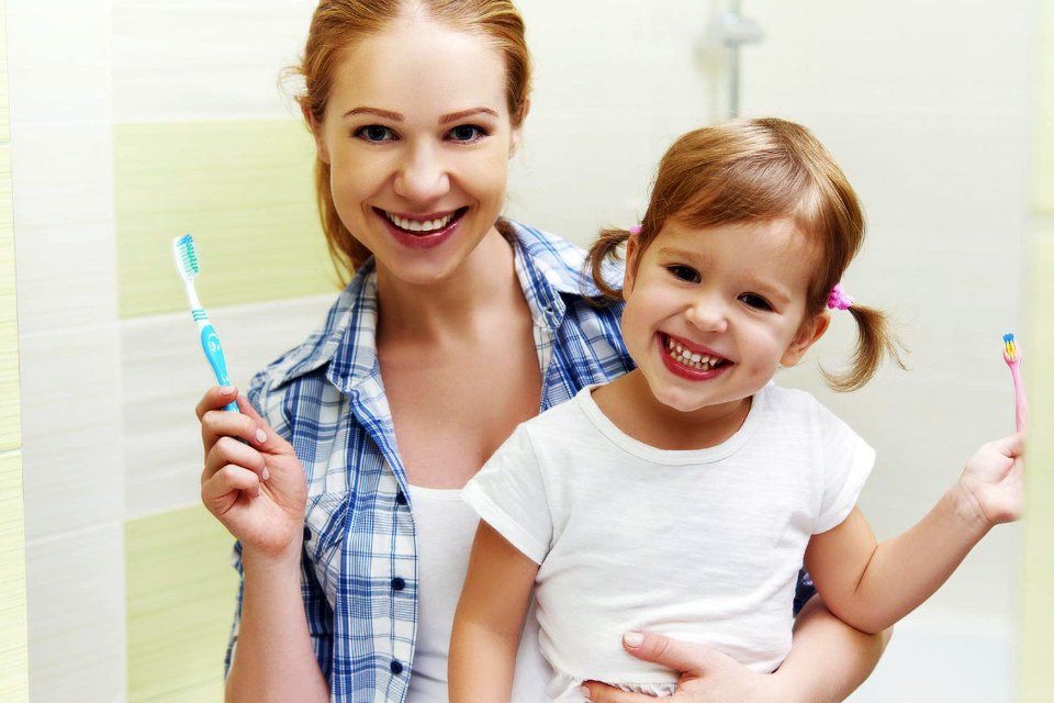 Una donna e un bambino che sorridono dopo un trattamento odontoiatrico