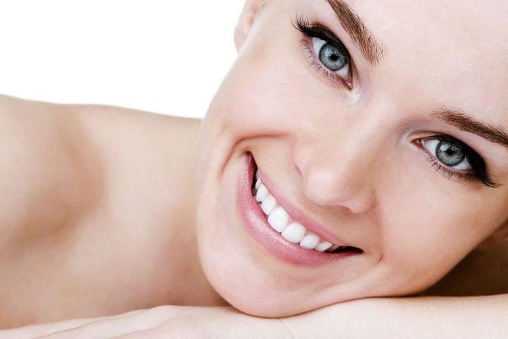 Donna che sorride dopo un trattamento di sbiancamento dei denti