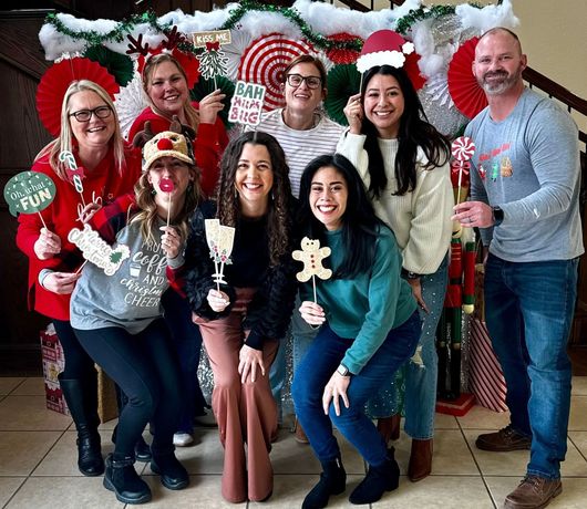 A group of people are posing for a picture in front of a christmas photo booth.