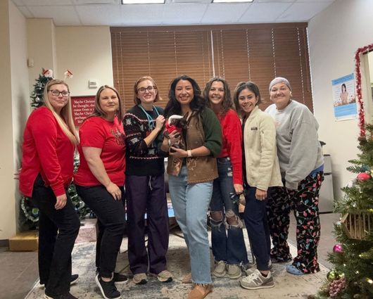 A group of people are posing for a picture in Christmas attire.