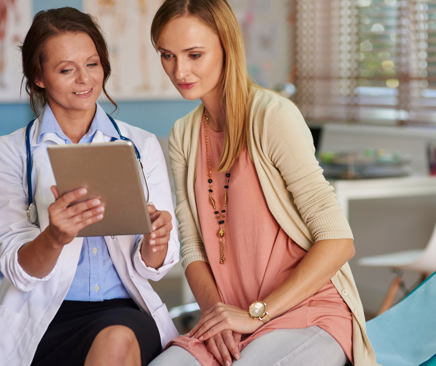 A doctor and a patient are looking at a tablet together