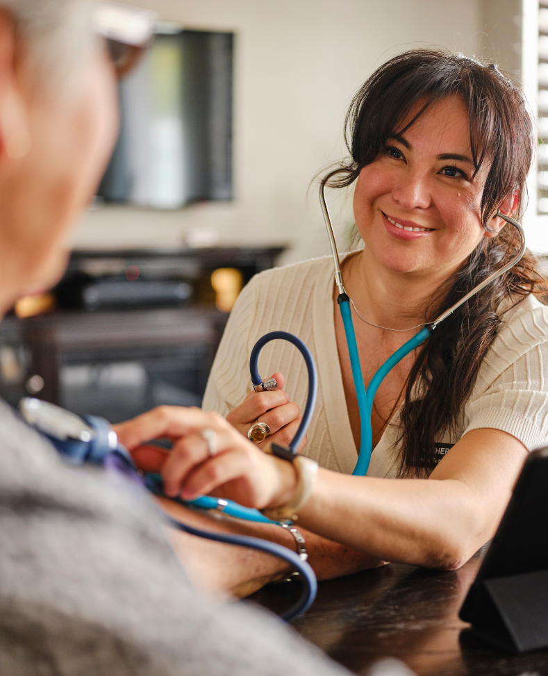 A woman is listening to a man's heart with a stethoscope.