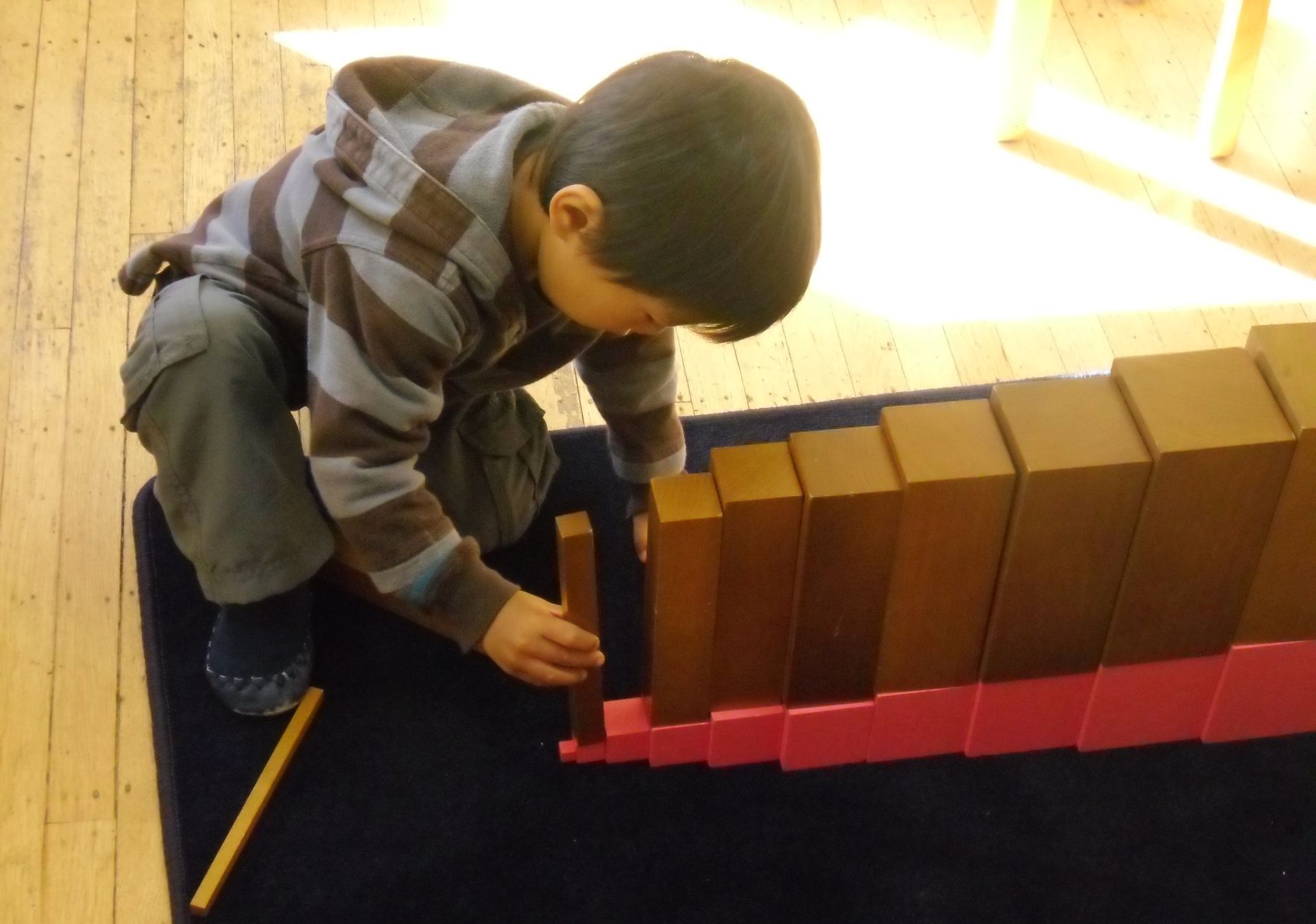 Montessori child working with sensorial materials