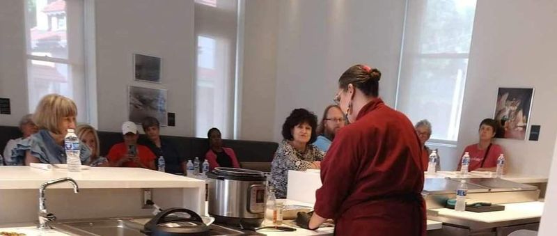 Melissa teaching a cooking demonstration to a seated group