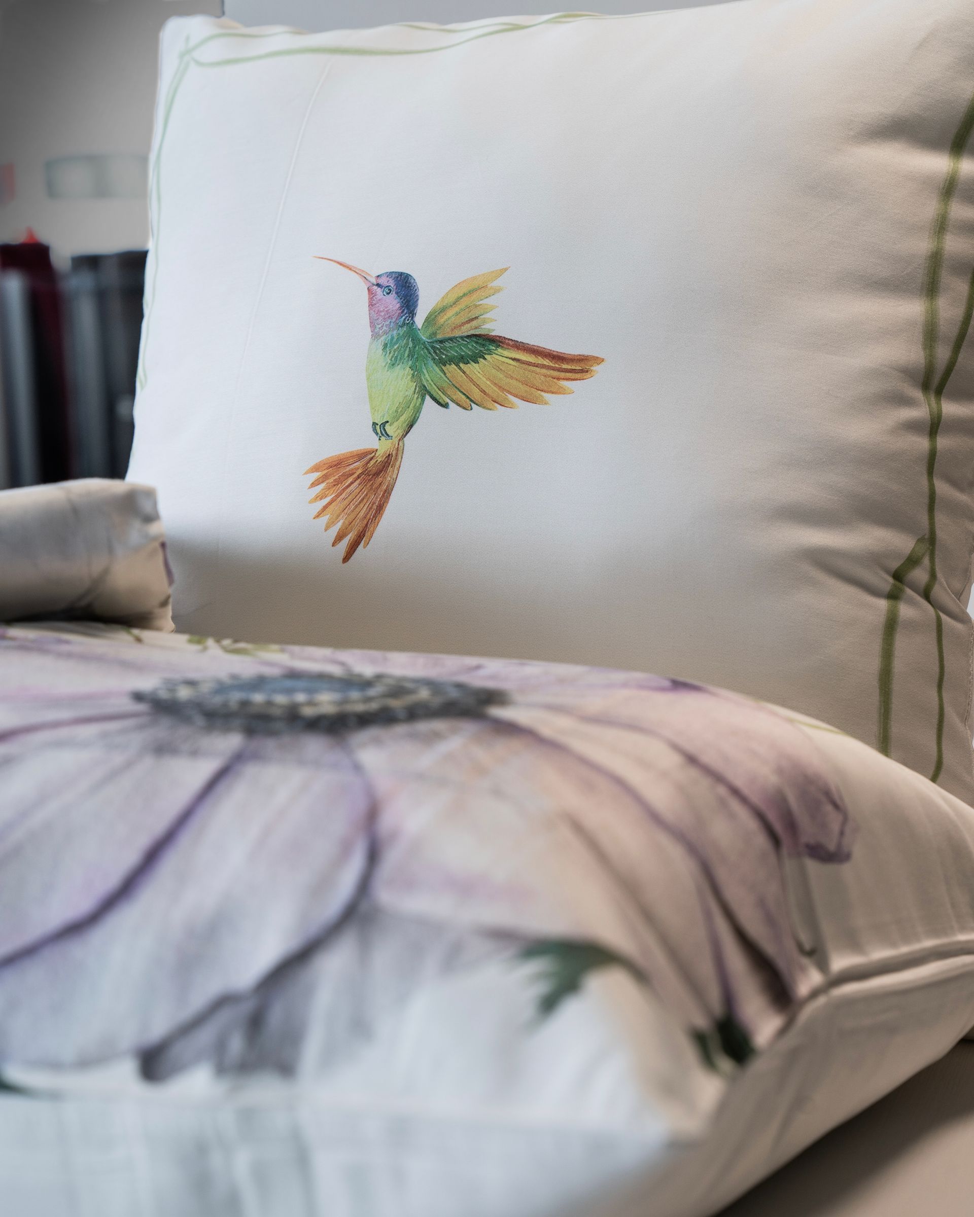 Cuscini con un colibrì e un grande motivo floreale.