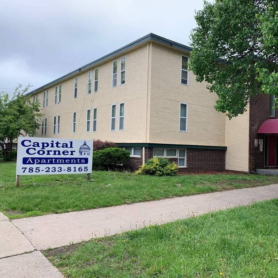 Capital Corner Apartments building with a sign on the lawn.
